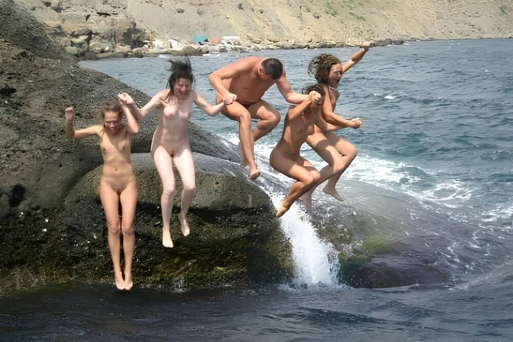 Mens and girls nudists on a beach - Interaction with nature through naturism and nudism